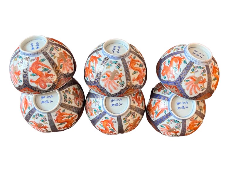 Puede incluir: Seis cuencos de cer&aacute;mica decorativos con dise&ntilde;os intrincados. Cada cuenco presenta un vibrante motivo de drag&oacute;n naranja, complementado con detalles en azul, dorado y blanco. Los cuencos est&aacute;n dispuestos en una configuraci&oacute;n apilada, mostrando su detallada artesan&iacute;a y estilo art&iacute;stico.