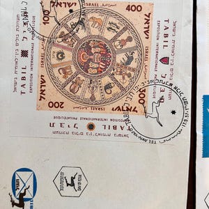 以下が含まれることがあります： イスラエルの切手のコレクション。黄道十二宮のデザインの切手と「TABIL EXPOSITION INTERNATIONALE PHILATELIQUE ISRAEL」の文字が特徴です。他の切手には「TEL AVIV-YAFO」の文字と様々な額面が含まれています。