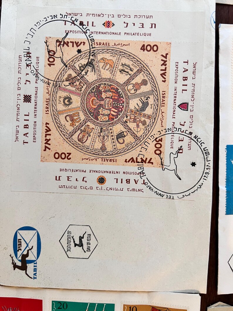 以下が含まれることがあります： イスラエルの切手のコレクション。黄道十二宮のデザインの切手と「TABIL EXPOSITION INTERNATIONALE PHILATELIQUE ISRAEL」の文字が特徴です。他の切手には「TEL AVIV-YAFO」の文字と様々な額面が含まれています。