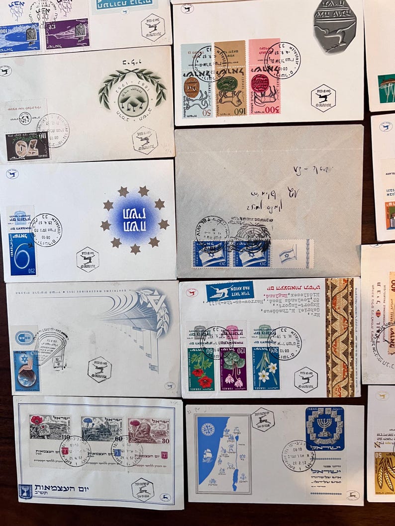 以下が含まれることがあります： 様々なデザインと色を持つ、ヴィンテージの封筒と切手のコレクション。封筒には、花柄、地図、歴史的シンボルなど、ヘブライ語のテキストと画像が印刷された切手が貼られています。一部の封筒には消印と手書きのメモがあります。
