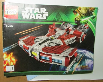 May include: A LEGO Star Wars set box featuring a red, white, and gray spaceship model. The box has the LEGO and Star Wars logos, the set number 75025, and an image of Yoda with a lightsaber. The background is a space scene.