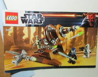 May include: LEGO Star Wars set 9491 box art. The image features a brown and tan vehicle with several minifigures, including Darth Maul and a Jedi. The Star Wars logo and LEGO logo are visible. The background is a desert scene.