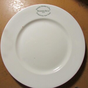 May include: A white ceramic plate with a wide rim. The plate has a circular design with the text "Niagara Steamer Co. No. 2 Organized Nov 29 1868 Poughkeepsie New York" printed in a circular pattern near the top.