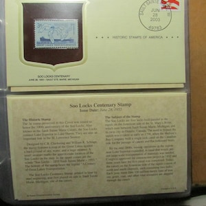 May include: A commemorative stamp from the Historic Stamps of America series, featuring a blue and white image of the Great Lakes Transportation. The stamp is encased in a cream-colored holder with text and a 2003 postmark.