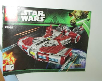 May include: A Star Wars LEGO set box featuring a red, white, and gray spaceship model with blue laser beams. The box has the Star Wars logo and an image of Yoda. The set number is 75025.