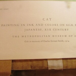 May include: A close-up of a printed document from The Metropolitan Museum of Art. The text reads "CAT, Painting in ink and colors on silk by Toko, Japanese, XIX Century." The document is a gift in memory of Charles Stewart Smith, 1914.