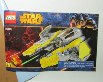 May include: A LEGO Star Wars set box featuring a yellow and gray spaceship with a transparent cockpit. The box has the LEGO and Star Wars logos, the number 75038, and a warning about small parts.