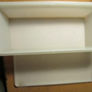 May include: A rectangular, off-white plastic storage container with a matching flat lid. The container features high, smooth walls and a deep, open interior, while the lid is positioned directly below it, showing a simple, clean design.