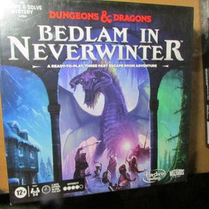 May include: A Dungeons & Dragons Bedlam in Neverwinter board game box featuring a large purple dragon illustration, a snowy village scene, and a group of adventurers. The text reads Dungeons & Dragons, Bedlam in Neverwinter, and A Ready-to-Play, Three Part Escape Room Adventure.
