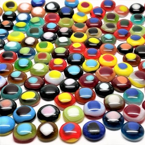 May include: A collection of colorful glass mosaic tiles with various patterns and designs. The tiles are round and have a smooth, glossy finish. They are perfect for crafting and decorating projects.