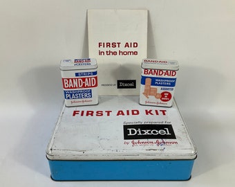 Dixcel Home First Aid Tin & Band-Aid Boxes Set c1960s. Boîtes de rangement rétro à collectionner. Accessoires de cinéma/télévision/scène. Mallette de premiers secours en acier moderne