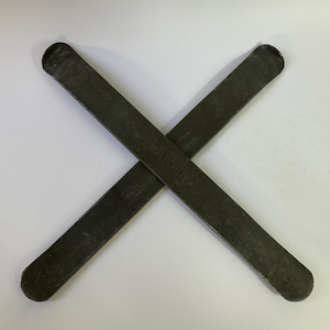 Könnte beinhalten: Zwei dunkelgraue Metall-Reifenheber kreuzen sich. Die Hebel haben abgerundete Enden und das Wort "HALFORD" ist auf einem von ihnen zu sehen. Der Hintergrund ist eine schlichte weiße Oberfläche.