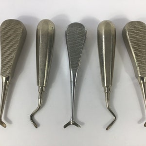 May include: Five silver dental tools with different shaped tips. The tools have textured handles.