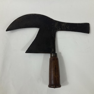 May include: A curved, black metal axe with a wooden handle. The axe has a unique shape with a curved blade and a straight handle.