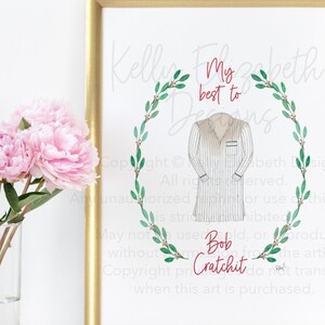 May include: A framed print with a gold border features an illustration of a striped robe within a green wreath. The text "My best to Bob Cratchit" is written in red script. Pink peonies in a glass vase are in the foreground.