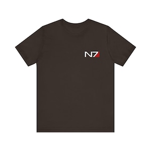 Puede incluir: Una camiseta marrón oscuro con un logotipo N7 blanco en la parte delantera. La N es roja.
