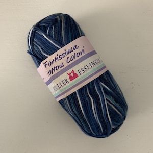 May include: A ball of blue and white yarn with a label that reads "Forhissina,  Lotou Colori, Schuller Esslinger."