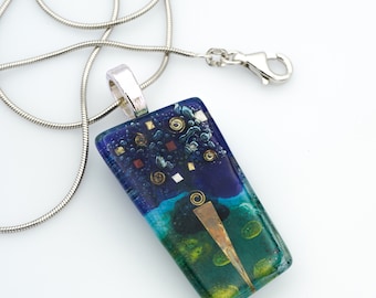 May include: A silver chain necklace with a rectangular glass pendant featuring a blue, green, and gold abstract design. The pendant has a silver bail.