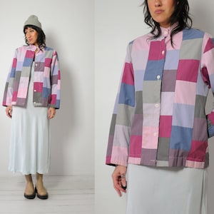 May include: A patchwork button-up shirt with a collar, long sleeves, and a variety of colors including pink, purple, blue, and gray.