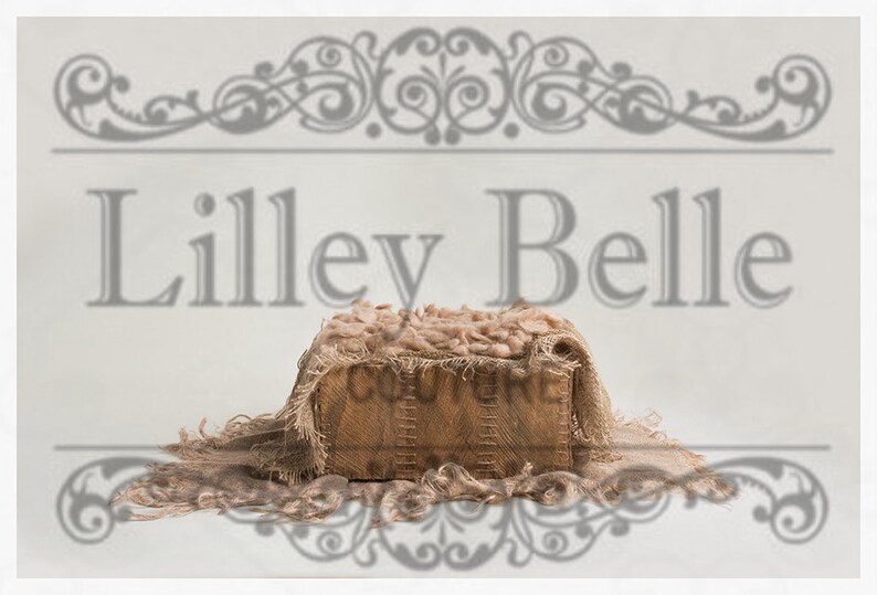 May include: A rustic wooden box with a burlap fabric lid and a light brown fuzzy blanket inside. The box is sitting on a white background with the text "Lilley Belle" above it.