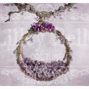 May include: A purple and green floral wreath with a purple fuzzy nest inside. The wreath is hanging from a branch with the text "Lily Belle Couture" in the background.