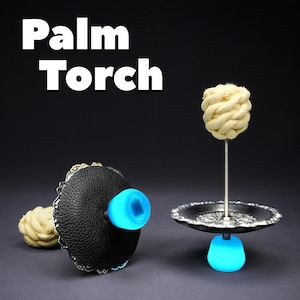 May include: The image shows a palm torch with the text "Palm Torch" in white. The torch has a black leather base with a blue light, a decorative silver tray, and a beige rope head. The design is set against a dark background.