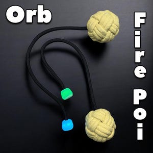 May include: Two yellow fire poi with black cords and glow-in-the-dark orbs attached. The text "Orb Fire Poi" is written vertically on the right side of the image.