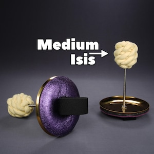 Könnte beinhalten: Zwei Feuer-Poi-Requisiten mit cremefarbenen, geflochtenen Affenfaustknoten auf Metallstielen. Eines hat eine violette, texturierte Scheibe mit schwarzem Riemen, das andere eine goldfarbene Basis. Der Text im Bild lautet Medium Isis mit Pfeil.