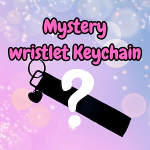 May include: Black wristlet keychain with a heart charm and a question mark. Mystery keychain.