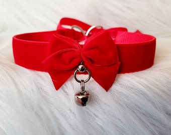 May include: A red velvet choker with a matching bow and a silver bell charm.