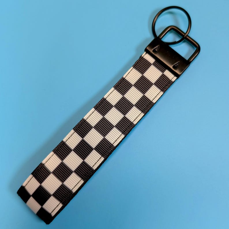 May include: Black and white checkered keychain with a black metal ring and clasp.