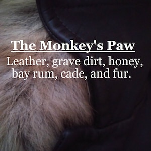 Może przedstawiać: Zbliżenie na brązową skórzaną kurtkę z kołnierzem z futra. Na kurtce nadrukowany jest tekst "The Monkey's Paw Leather, grave dirt, honey, bay rum, cade, and fur."