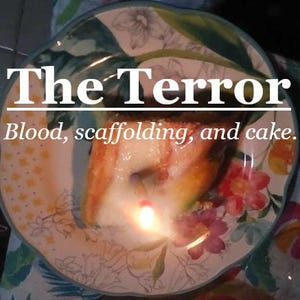 May include: A plate with a floral design holds a slice of cake with a lit candle. The text "The Terror" and "Blood, scaffolding, and cake" are displayed on the plate.