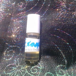 Peut inclure: Un petit flacon en verre transparent avec un bouchon blanc et une étiquette bleue qui dit "Mary-ka's Trunk".