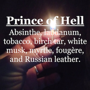 May include: A hand holding a lit match with the text "Prince of Hell" and a list of ingredients: absinthe, labdanum, tobacco, birch tar, white musk, myrtle, fougère, and Russian leather.