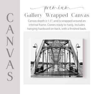 The image is a black and white photograph of a bridge with a textured surface, featuring a series of arches and trusses.