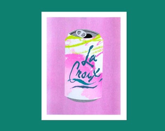 May include: A pink and white La Croix sparkling water can with green and blue paint splatters on a pink background.