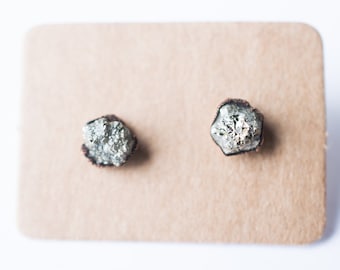 Op de afbeelding: Een paar zilveren en koperen oorbel studs met een ruw, natuurlijk pyriet-steenontwerp.