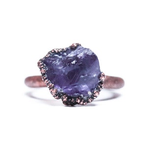 May include: A purple amethyst gemstone ring with a copper band and a copper beaded setting.