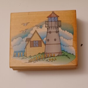 Timbro in gomma con scena di faro e cottage sul mare montato su legno di Hero Art H1055