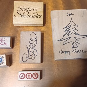 Lote de 6 encantadores sellos de goma navideños montados en madera con temática de Navidad "Cree en los milagros" y "Alegría".