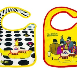 Könnte beinhalten: Zwei gelbe Baby-Lätzchen mit Beatles-Motiv. Ein Lätzchen zeigt ein schwarz-weißes Punkte-Muster mit einem gelben U-Boot und dem Text "The Beatles". Das andere Lätzchen zeigt einen gelben Hintergrund mit einem Bild der Beatles in ihrem gelben U-Boot und dem Text "The Beatles Yellow Submarine".
