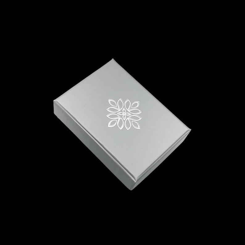 May include: A grey gift box with a white floral design on the top.