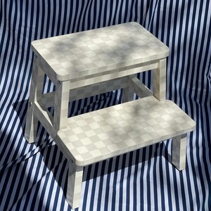 May include: A white two-step stool with a checkered pattern. The stool is made of wood and has a simple design.