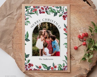 Peut inclure: Une carte de Noël représentant une famille de cinq personnes dans une arche en aquarelle avec des baies rouges et des feuilles vertes. Le texte "Merry Christmas" est écrit en cercle au-dessus de l'arche. Le nom de famille de la famille, "The Andersons", est écrit sous l'arche.