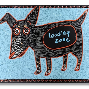May include: A black dog with a red outline stands on a light blue background with a white swirl pattern. The dog has a black oval on its back with the words "loading zone" written in white.