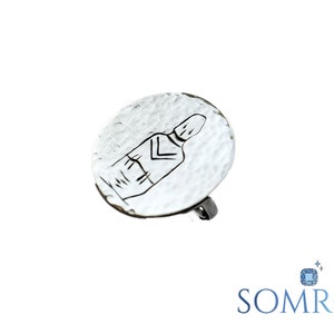May include: Silver ring with a hammered round face featuring a line drawing of a person.