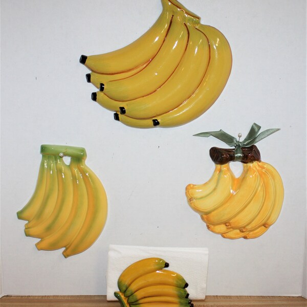 3 banana wall plaques and banana napkin holder, 2 plaques are ceramic 2 are plastic