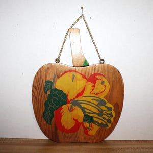 vintage wooden Apple shaped cutting board with knife as the stem and a small chain attached for hanging, fruit design on front