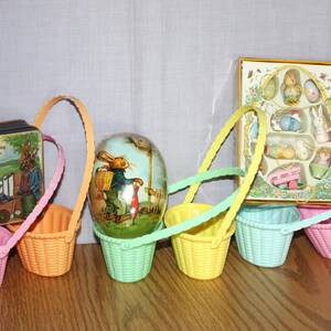 6 small Pastel plastic Easter/Spring baskets, 1995 Easter book tin, box of new small wood Easter ornaments, and new paper mache egg
